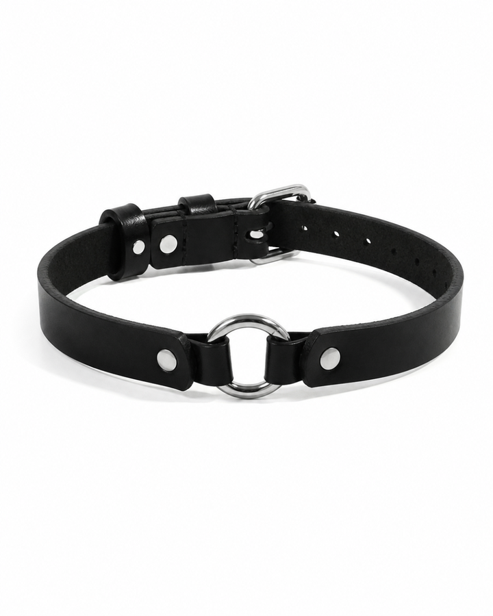 Black leather Halo Collar on white background showing slim strap, silver O-ring centre detail with flanking dome-head rivets, and adjustable pin buckle