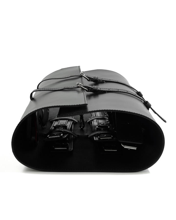 BDSM Bondage Kit leather roll carry case - side view of closed cylindrical black leather bag with tie closure and cuffs visible inside, Leathersubculture
