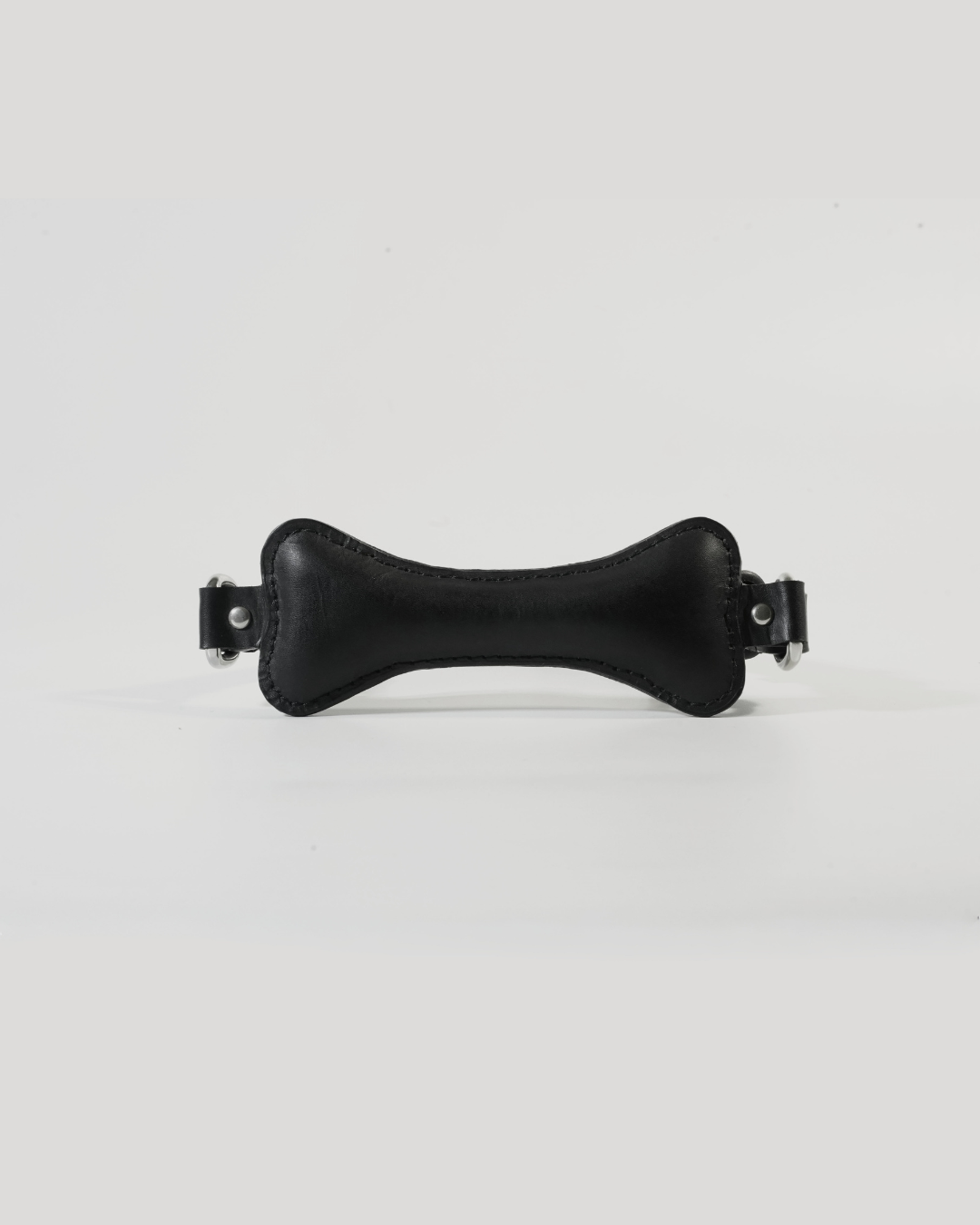 Back of Fetch leather bone gag showing SUBCULTURE embossed leather strap and roller buckle closure