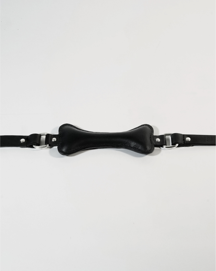 Fetch leather bone gag flat lay, black leather bone-shaped bite piece with D-rings on either side