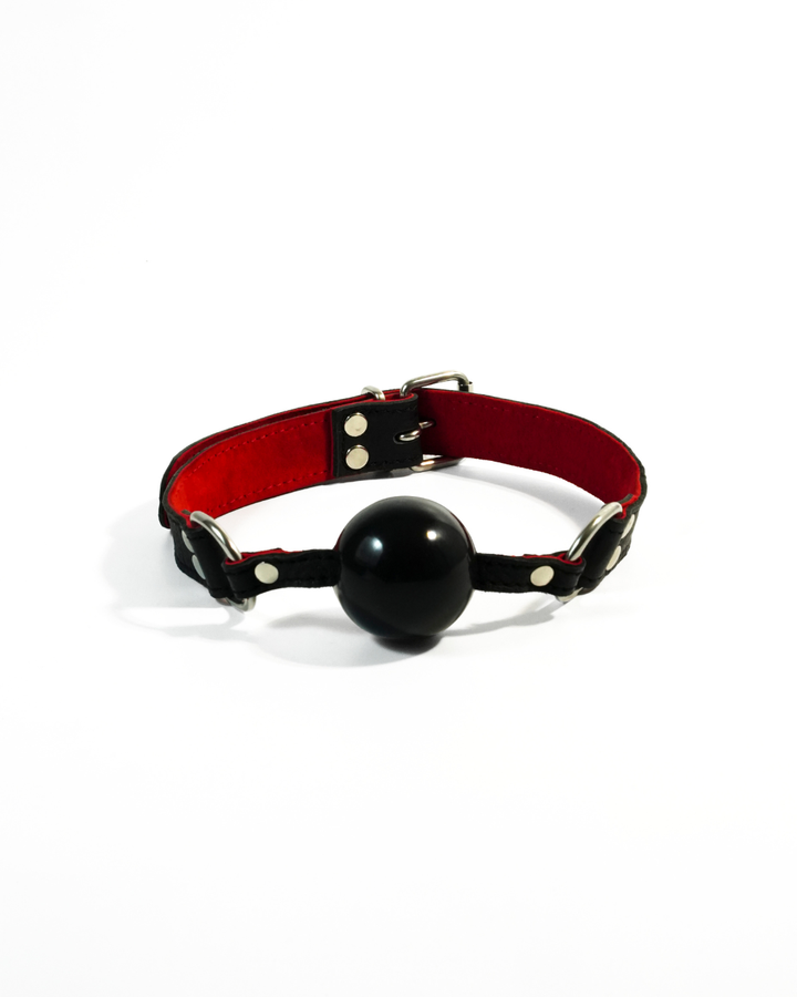 Silicone mouth ball gag from BDSM Bondage Kit - black ball with adjustable leather strap, red suede lining and silver buckle hardware, Leathersubculture