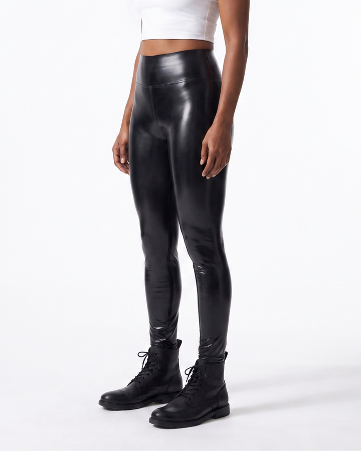 Three-quarter side view of women's glossy black latex leggings, showing wide waistband and skin-tight contoured fit