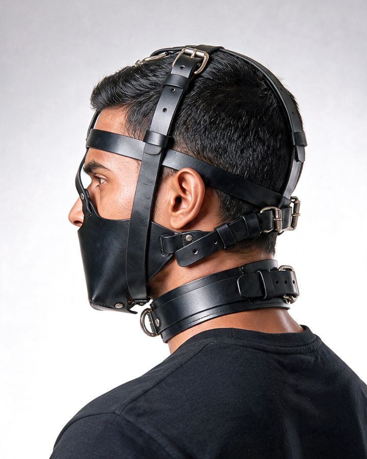 Black leather muzzle mask worn side view with adjustable leather straps