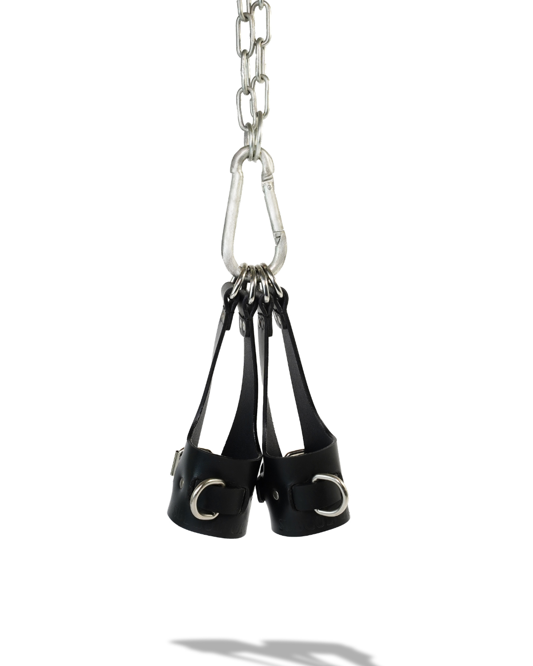 Aloft suspension cuffs hanging from steel carabiner, D-rings gathered at top of leather bridge straps, product shot on white background