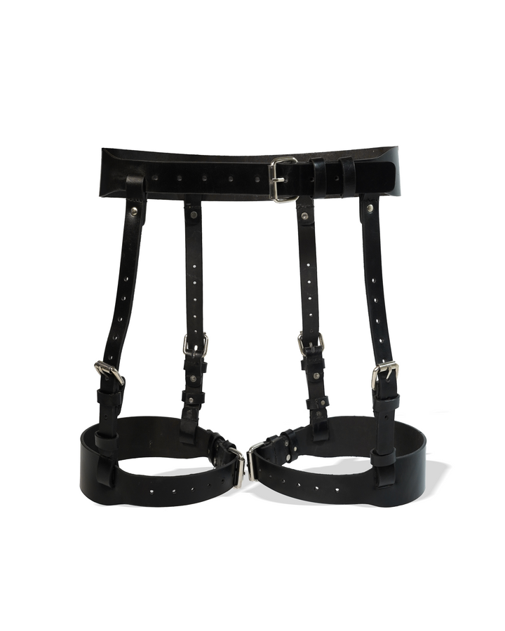 Black leather thigh suspender product shot on white background showing wide waist belt with center buckle, four-buckle double connector straps, and wide thigh band cuffs